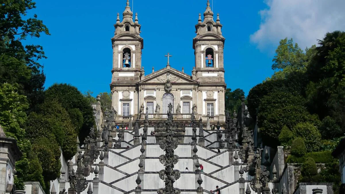 Illustration stylisée d'un escalier baroque monumental menant à une église au sommet d'une colline verdoyante, inspiré par le patrimoine de Braga.